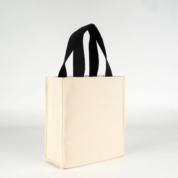 Small natural canvas tote bag held to show 12-inch handle drop