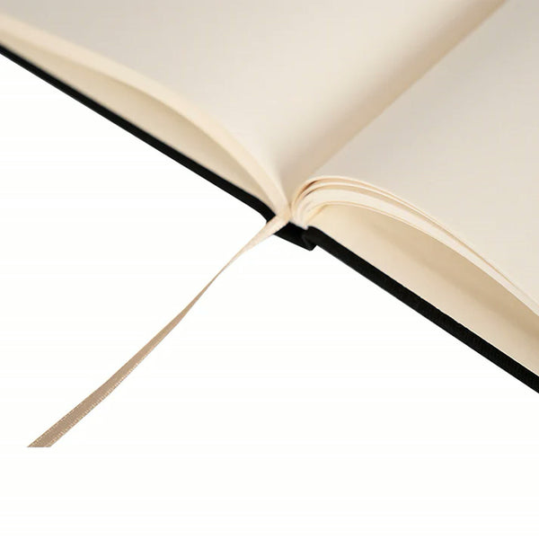 Close-up of the cream ribbon bookmark on a black canvas notebook | Pamusan.com