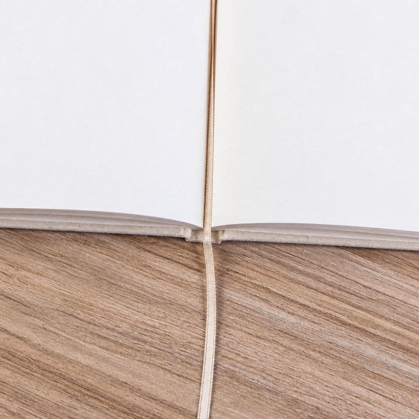 Close-up of the open blank canvas notebook: cream unlined pages, sewn spine and ribbon bookmark | Pamusan.com