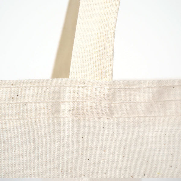 Close-up of a beige tote bag with a plain background