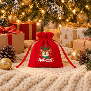 Rotes Samtsäckchen mit Motiv Schöne Adventszeit auf einer Strickdecke unter dem Weihnachtsbaum